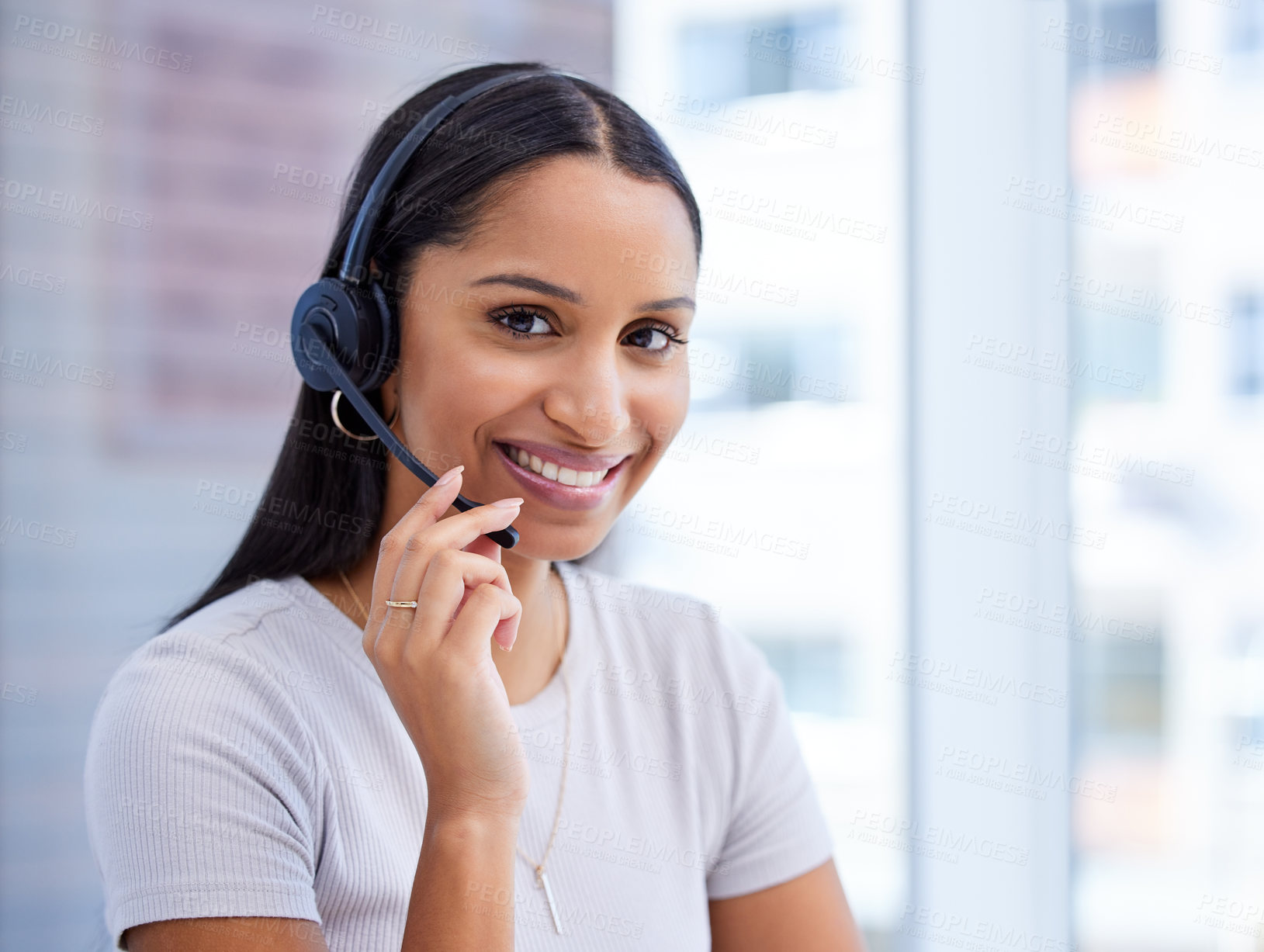 Buy stock photo Cropped portrait of an attractive young female call center agent working at her desk in the office