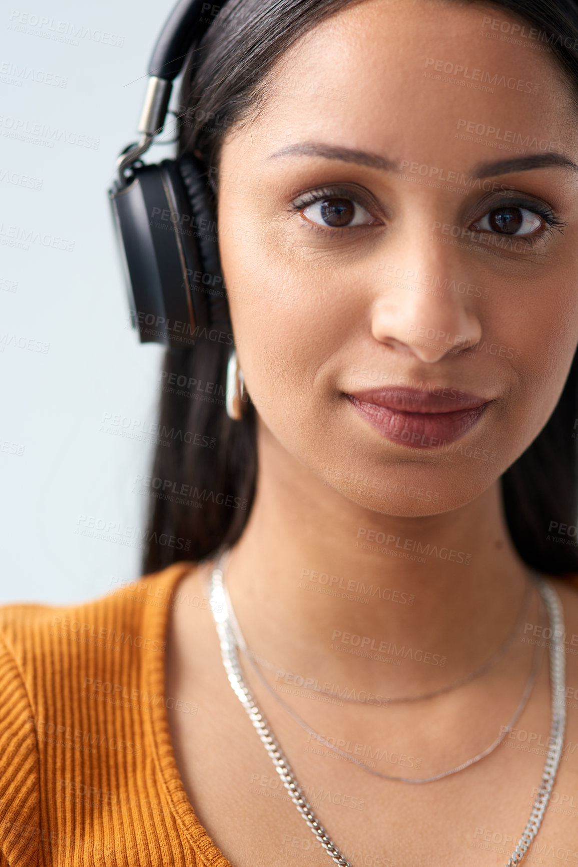 Buy stock photo Cropped portrait of an attractive young woman wearing headphones in studio against a grey background