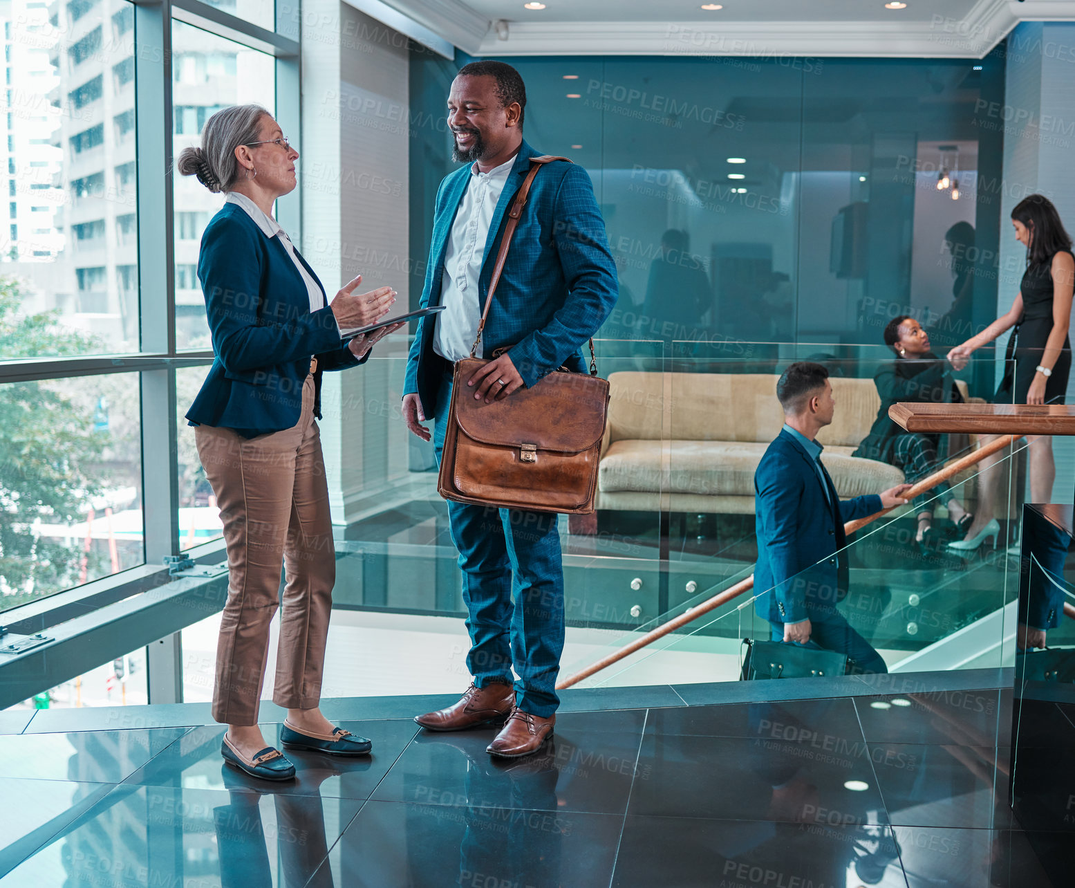 Buy stock photo Shot of two businesspeople using a digital tablet at work