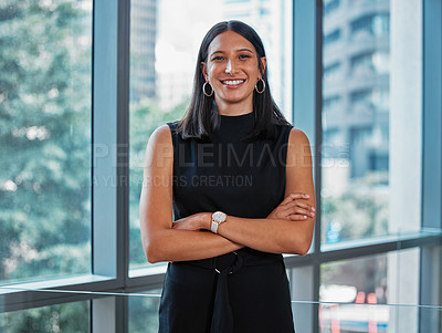 Buy stock photo Portrait shot of a young businesswoman standing with her arms crossed at work
