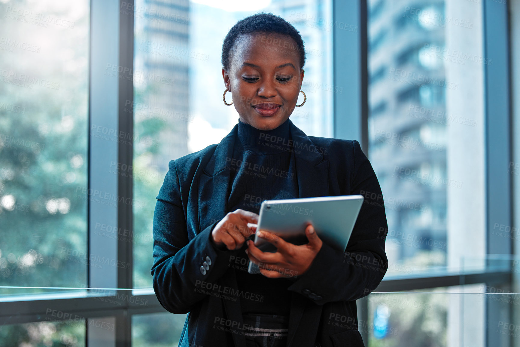 Buy stock photo Shot of a young businesswoman using a digital tablet at work