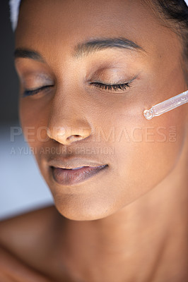 Buy stock photo Closeup shot of an attractive young woman using a dropper to apply serum to her face