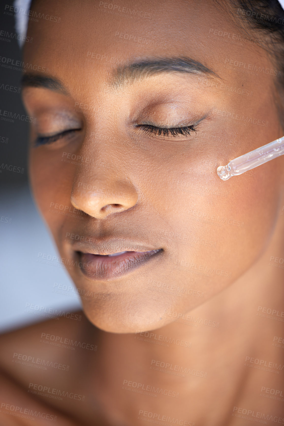 Buy stock photo Closeup shot of an attractive young woman using a dropper to apply serum to her face