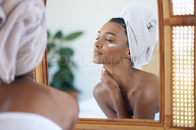 Buy stock photo Cropped shot of an attractive young woman examining her face in the mirror at home