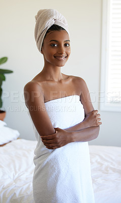 Buy stock photo Cropped portrait of an attractive young woman wrapped in a towel while standing with her arms folded in the bedroom