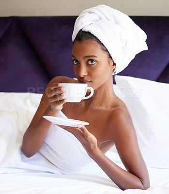 Buy stock photo Cropped portrait of an attractive young woman drinking tea while lying on her bed after a shower