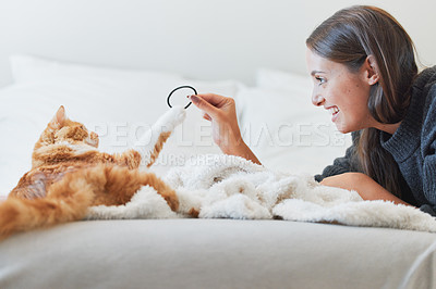 Buy stock photo Love, smile and woman playing with cat in bedroom of home for bonding or fun as pet owner. Bed, happy and toys with person teasing adorable kitten in apartment for morning or winter relaxation