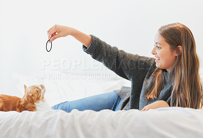 Buy stock photo Shot of a young woman playing with her cat at home