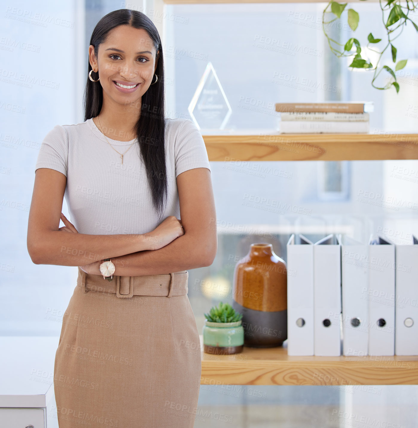 Buy stock photo Shot of an attractive young businesswoman standing alone in the office with her arms folded