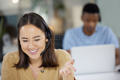 Buy stock photo Shot of a young businesswoman working in a call centre with her colleague in the background