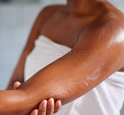 Buy stock photo Shot of a woman massaging lotion into her skin