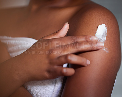 Buy stock photo Shot of a woman applying lotion to her body