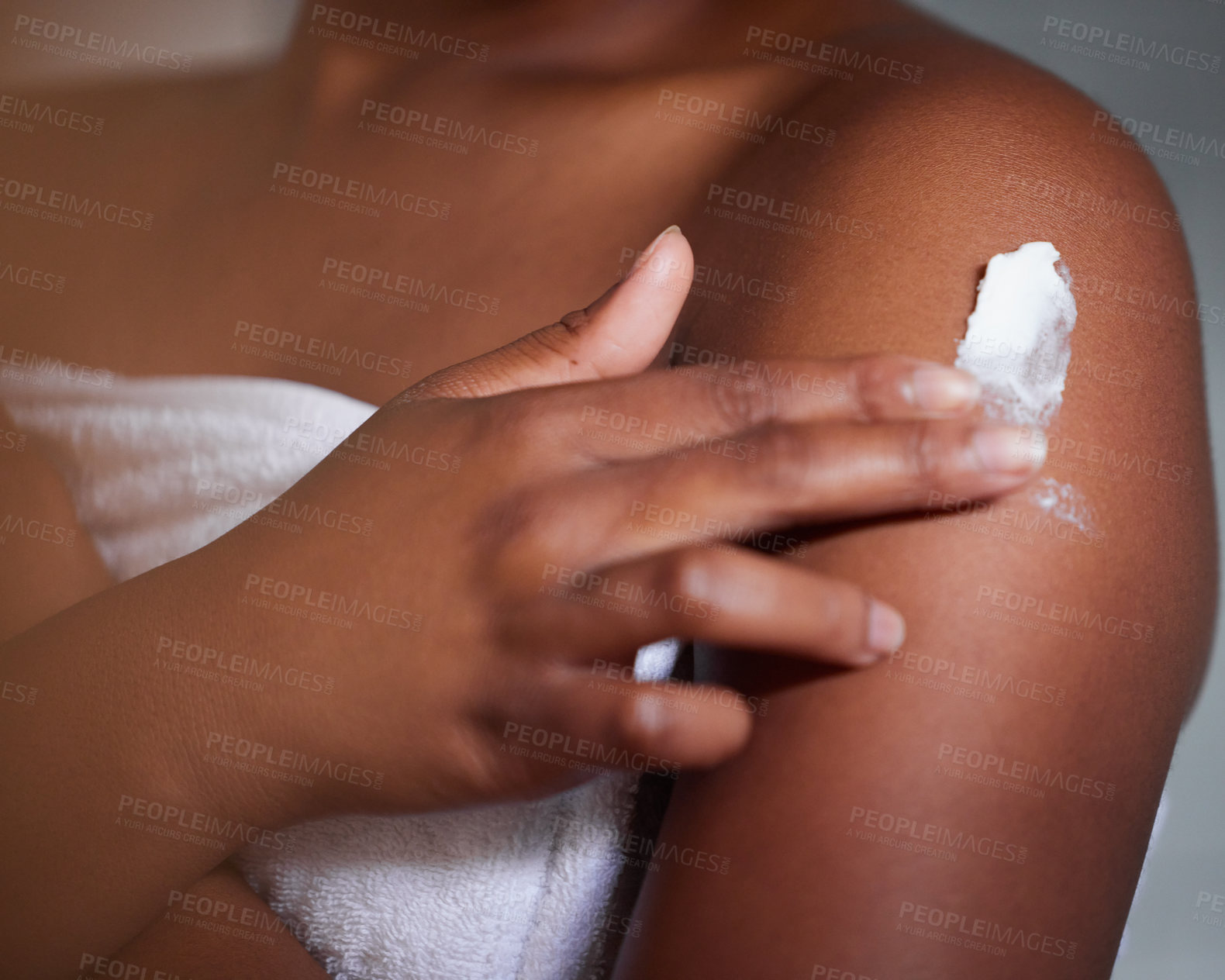 Buy stock photo Shot of a woman applying lotion to her body