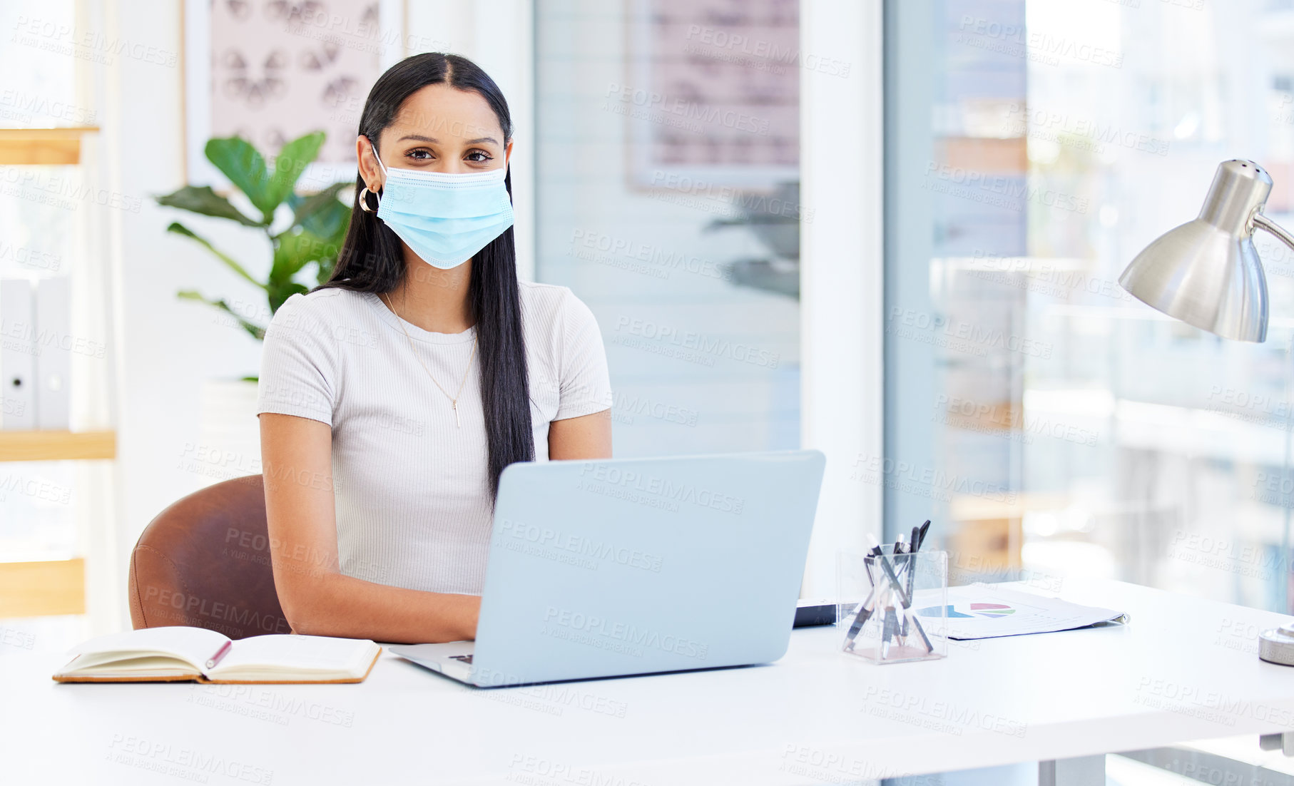 Buy stock photo Shot of a young businesswoman using her laptop at work