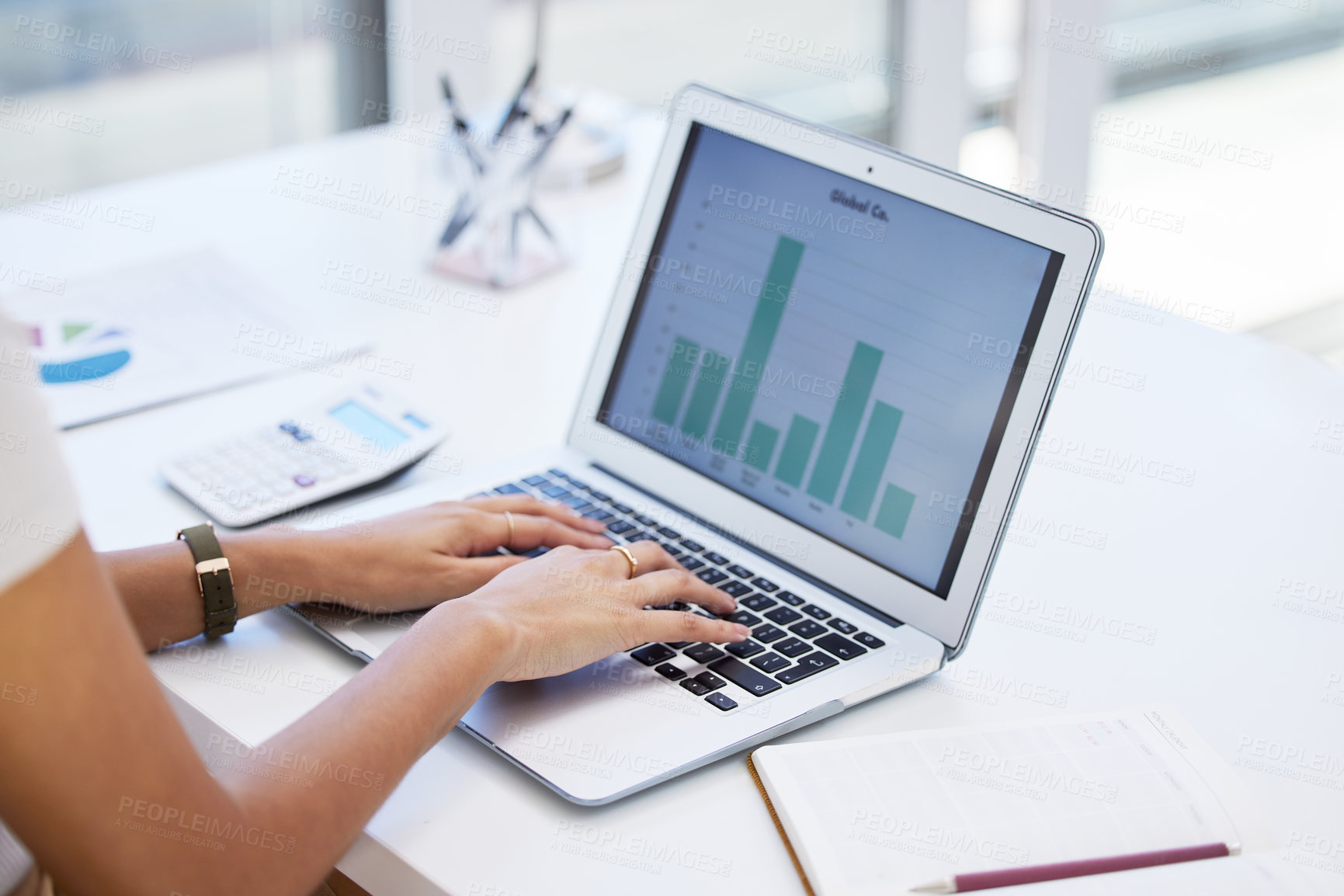 Buy stock photo Shot of a businesswoman using her laptop to compile spreadsheets