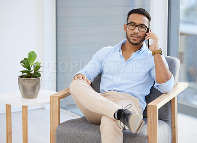 Buy stock photo Shot of a young businessman using a smartphone at work
