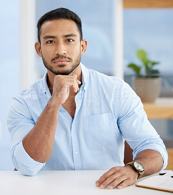 Buy stock photo Shot of a young businessman sitting at a desk at work