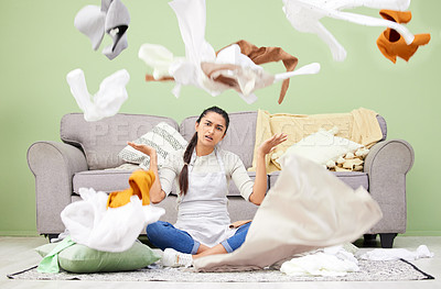 Buy stock photo Woman, home and laundry with stress, chaos and portrait by sofa on floor in living room for hygiene. Frustrated girl, person and throw clothes on carpet, apron and cleaning with housework in lounge