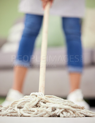 Buy stock photo Cropped shot of an unrecognizable woman standing and mopping her living room