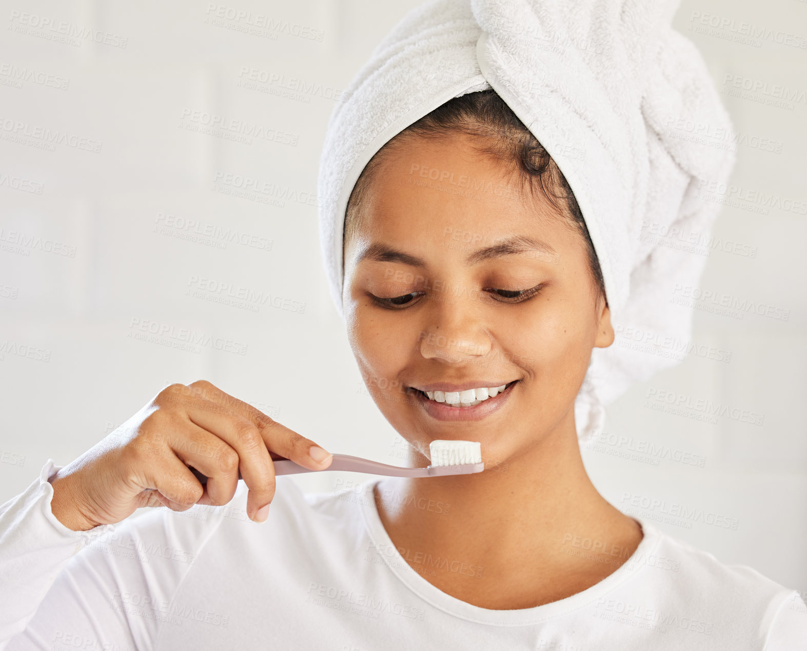 Buy stock photo Shot of a beautiful young woman brushing her teeth in the morning