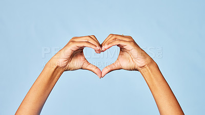 Buy stock photo Hands, heart and emoji with a person in studio on a blue background for love, health or social media. Affection, romantic and hand gesture with an adult indoor to show a sign or icon of romance