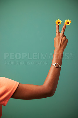 Buy stock photo Hand, peace sign and flower in studio for symbol, mockup space and kindness on green background. Fingers, emoji and sunflower for vegan or organic choice and health, plant and icon for vote on growth