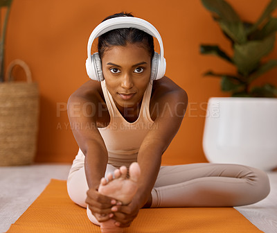 Buy stock photo Shot of a young woman stretching during a yoga routine against a studio background