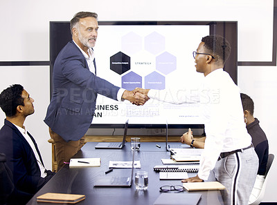Buy stock photo Shot of two businessmen shaking hands in a boardroom at work
