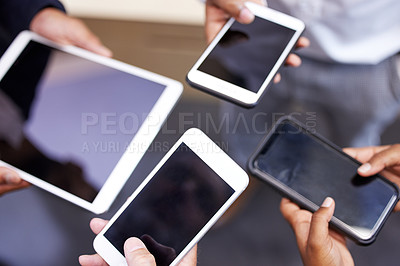 Buy stock photo Cropped shot of an unrecognizable group of businesspeople standing together in a circle and using technology