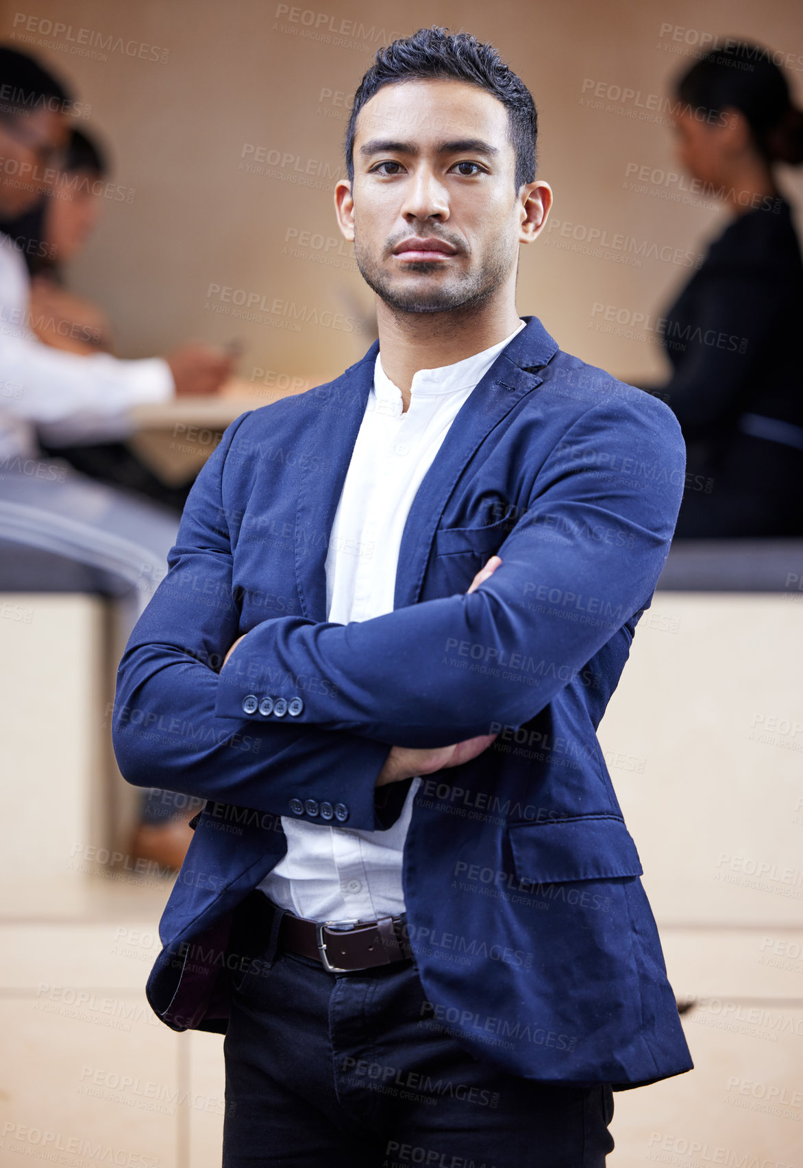 Buy stock photo Shot of a handsome young businessman standing in the office with his arms folded