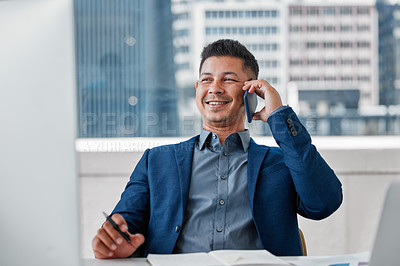 Buy stock photo Shot of a handsome young businessman sitting alone in the office and using his cellphone