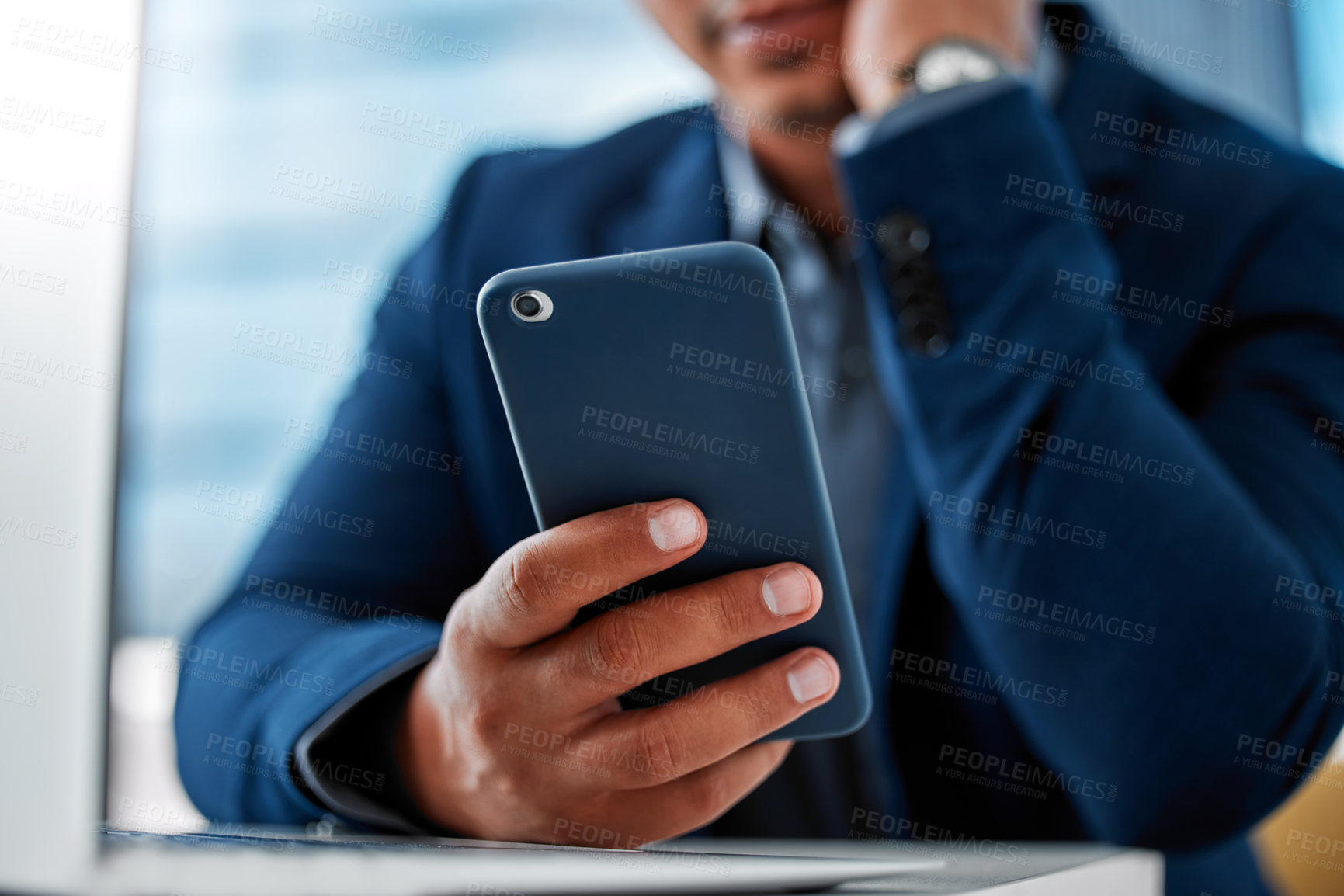 Buy stock photo Cropped shot of an unrecognizable businessman sitting alone in the office and using his cellphone