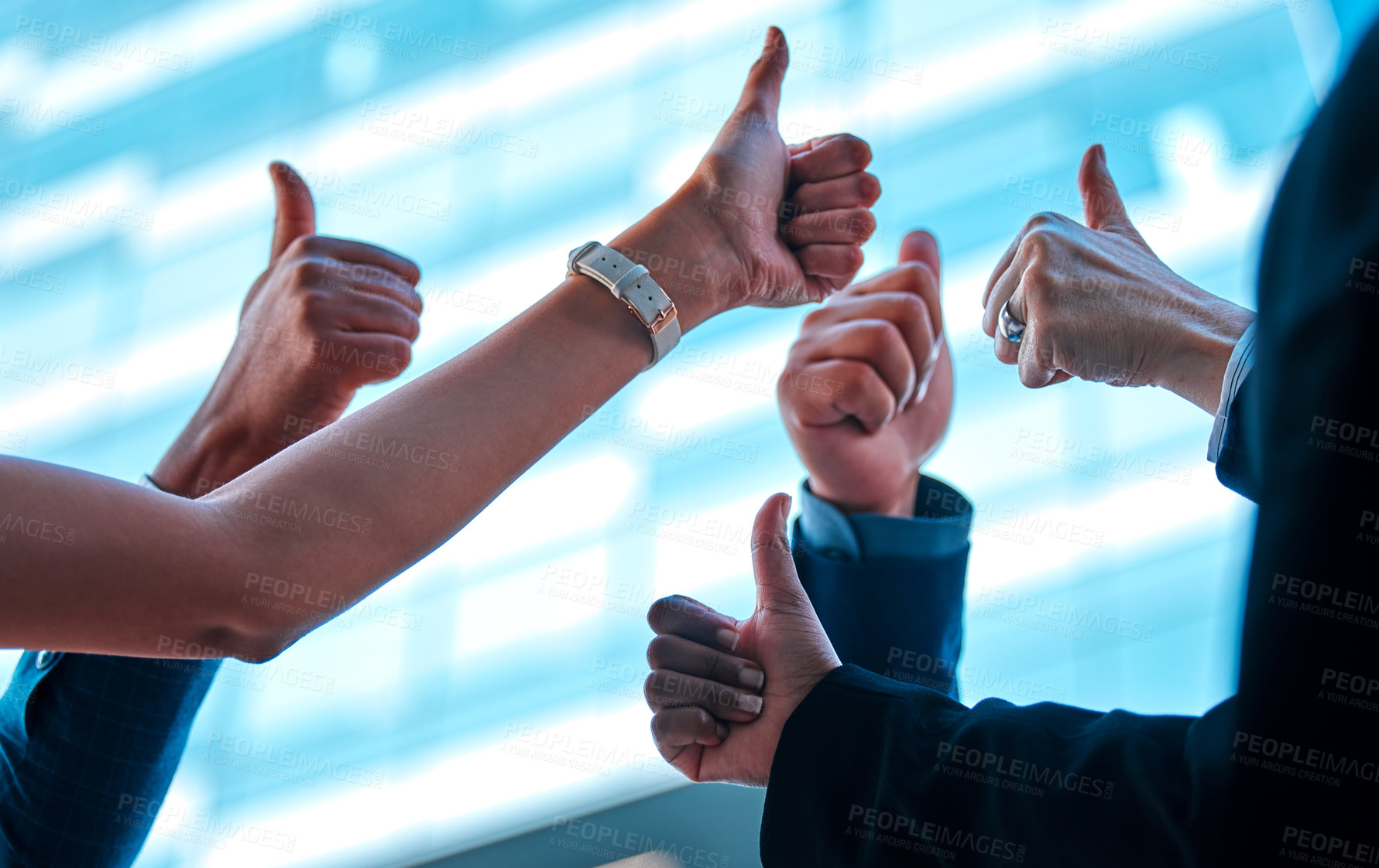 Buy stock photo Shot of a group of young businesspeople giving each other a thumbs up against an urban background