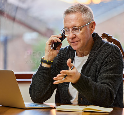 Buy stock photo Cropped shot of a handsome senior man making a phonecall while working on his laptop in the study