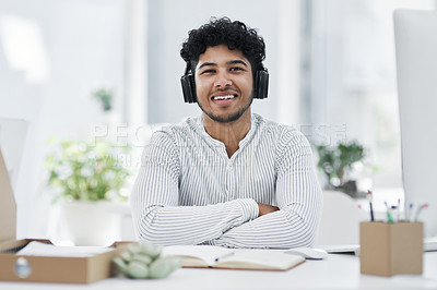 Buy stock photo Portrait of a young businessman wearing headphones while working in an office