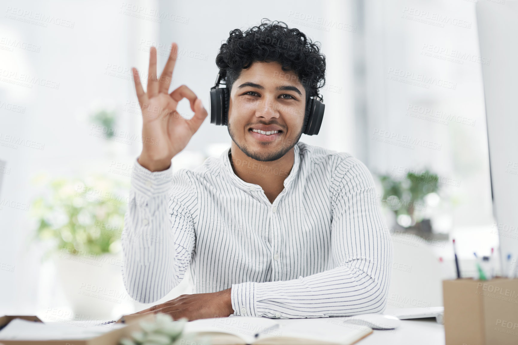 Buy stock photo Portrait of a young businessman gesturing an okay sign in an office