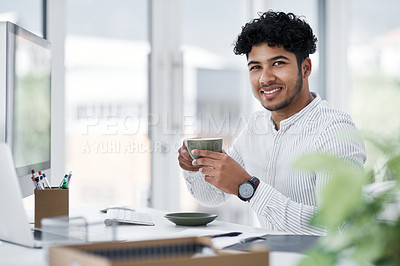 Buy stock photo Portrait of a young businessman drinking coffee while working in an office