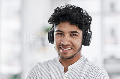 Buy stock photo Portrait of a young businessman wearing headphones in an office