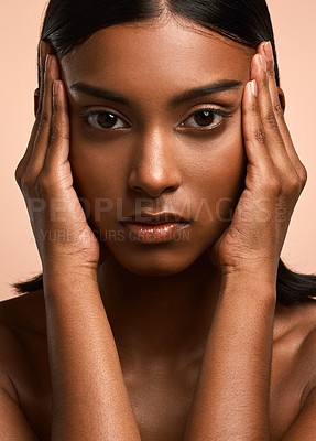 Buy stock photo Portrait of a beautiful young woman touching her face while posing against a brown background