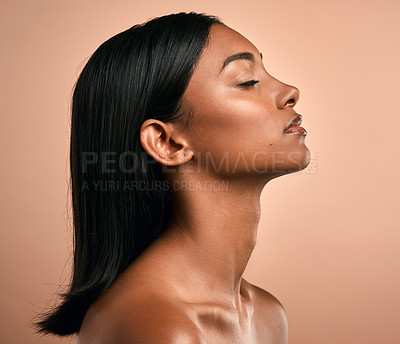 Buy stock photo Side shot of a beautiful young woman posing against a brown background