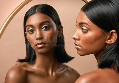 Buy stock photo Portrait of a beautiful young woman looking at a mirror and  posing against a brown background