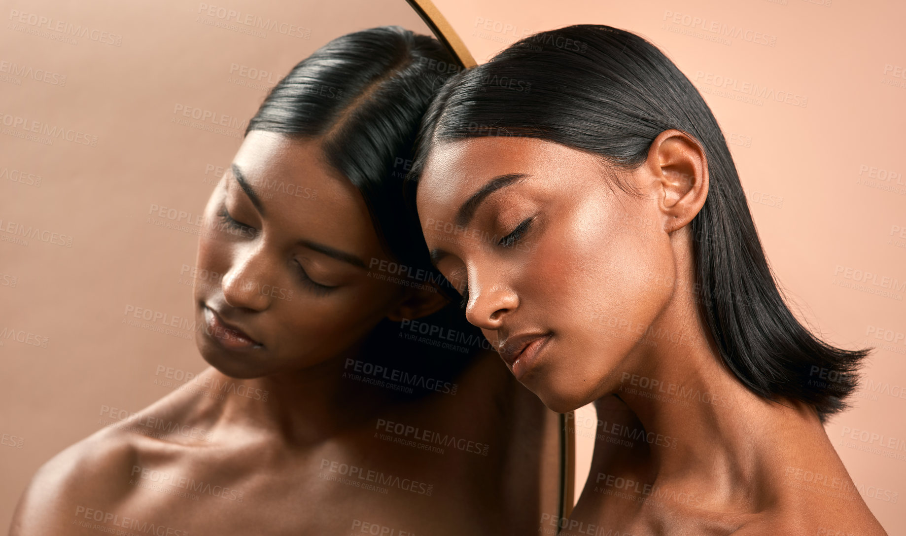 Buy stock photo Shot of a beautiful young woman resting her head on a mirror and posing against a brown background