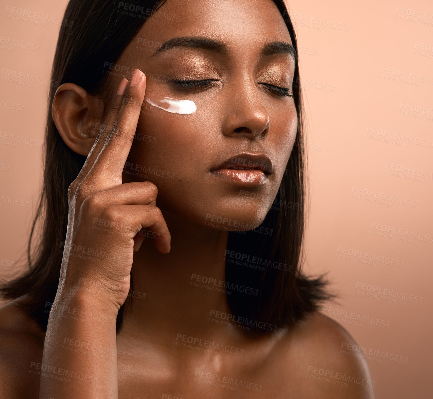 Buy stock photo Woman, moisturizer and skincare with lotion on face in studio for beauty on a brown background. Female person, model or applying cosmetics with cream for dermatology, health or anti aging treatment