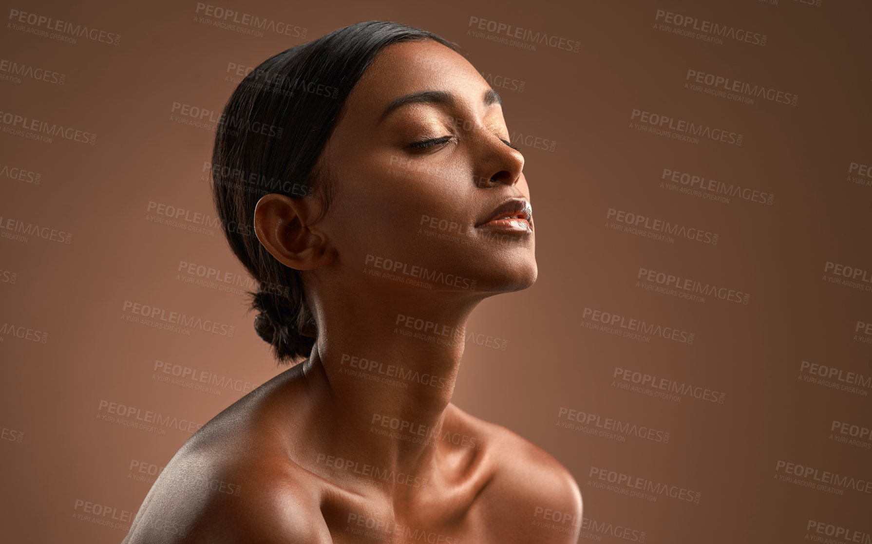 Buy stock photo Side shot of a beautiful young woman posing against a brown background