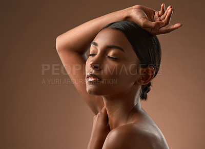 Buy stock photo Side shot of a beautiful young woman posing against a brown background