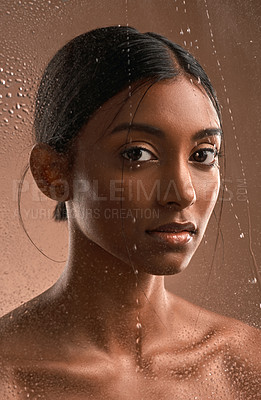 Buy stock photo Portrait of a beautiful young woman having a refreshing shower against a brown background