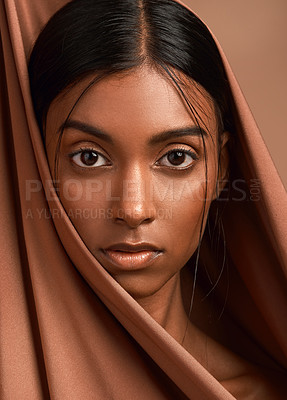 Buy stock photo Portrait of an attractive young woman wearing a head scarf against a brown background
