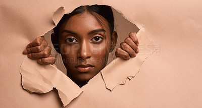 Buy stock photo Closeup portrait of a young attractive woman tearing through brown paper