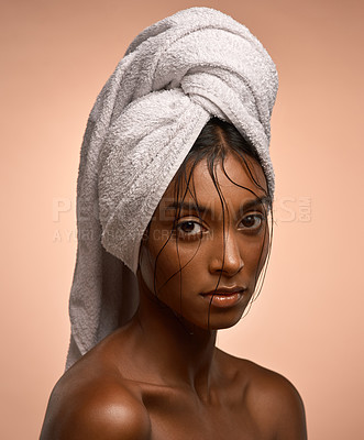 Buy stock photo Portrait of a beautiful young woman with her hair wrapped in a towel against a brown background