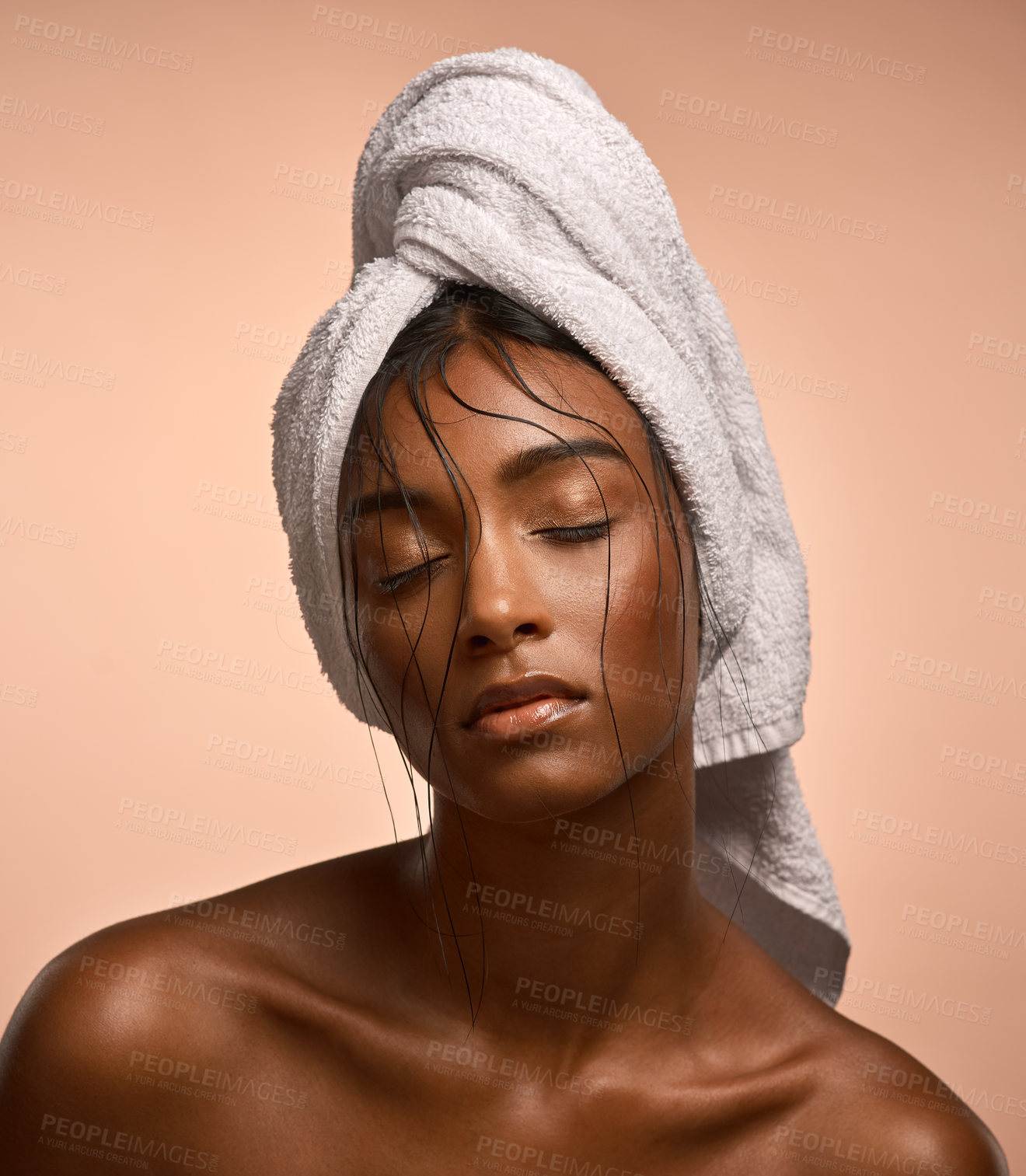 Buy stock photo Shot of a beautiful young woman with her hair wrapped in a towel against brown background